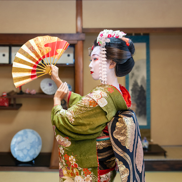 Maiko (Geisha in training) dancing with 'Sensu' folding fan in Japanese tatami room